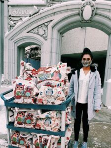 Young woman standing next to a cart full of gift bags